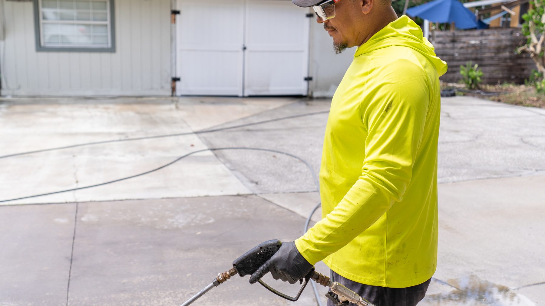 Ibrahim of Bluecrest Pro Services pressure washing a residential driveway in Central Florida
