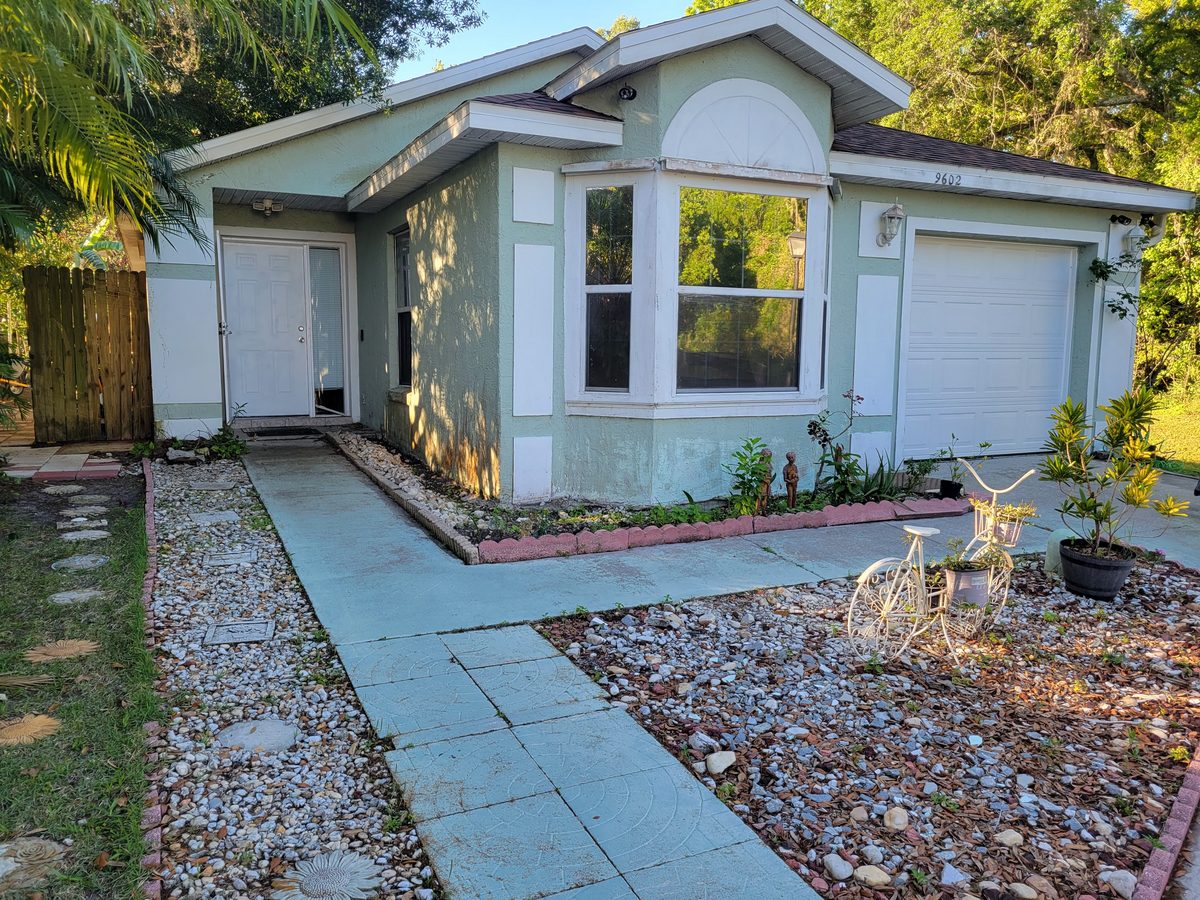 Faded green house exterior before professional repaint