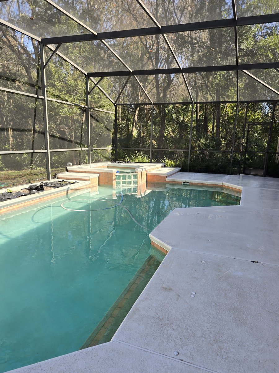 The same screen pool enclosure after Bluecrest cleaning, with a bright clean deck and clear screens